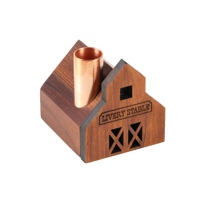Un petit bougeoir en bois d'écurie avec une cheminée en cuivre.